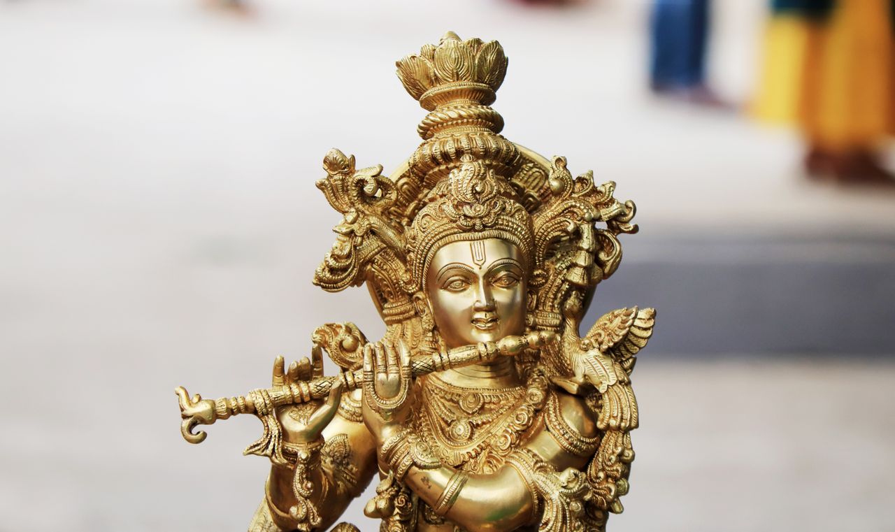 Detailed close-up of a golden Hindu deity figurine showcasing intricate artistry and religious significance.